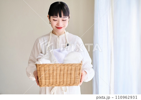 洗濯物を持つ若い女性 110962931