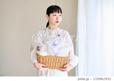 洗濯物を持つ若い女性 110962932