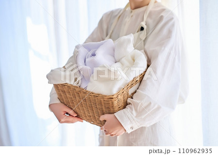 洗濯物を持つ若い女性 110962935