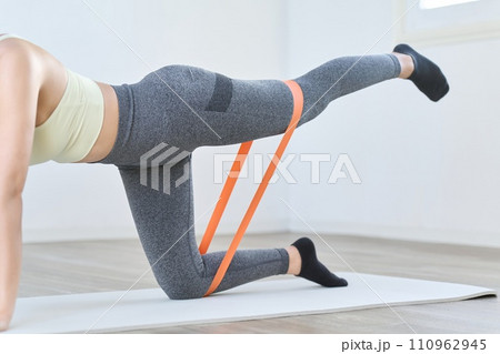 レジスタンスバンドを使って下半身のトレーニングをする女性	 110962945