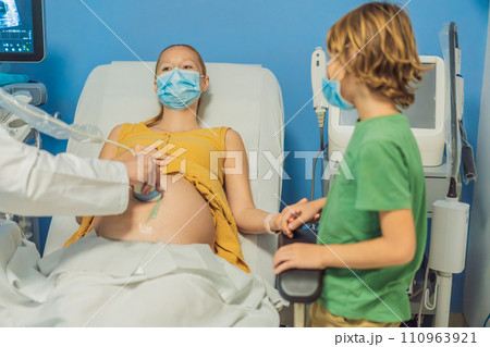 a pregnant mother's ultrasound visit, sharing the excitement with her son who eagerly awaits the arrival of his baby brother. A heartwarming portrayal of family bonds and the anticipation of new a pregnant mother's ultrasound visit, sharing the excitement with her son who eagerly awaits the arrival of his baby brother. A heartwarming portrayal of family bonds and the anticipation of new 110963921
