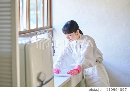 キッチンのシンクを掃除する若い女性 キッチンのシンクを掃除する若い女性 110964097