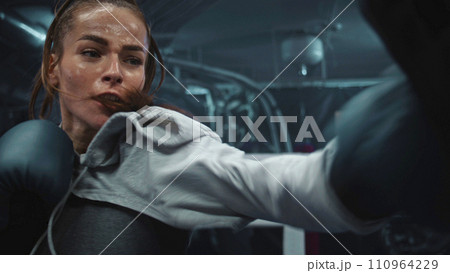 Close up of athletic woman hitting punching mitts while training Close up of athletic woman hitting punching mitts while training 110964229