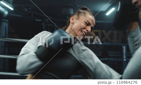 Female fighter in boxing gloves practicing fighting technique Female fighter in boxing gloves practicing fighting technique 110964276