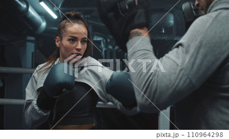 Female fighter in boxing gloves practicing fighting technique Female fighter in boxing gloves practicing fighting technique 110964298