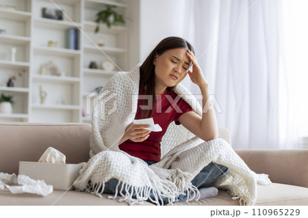 Seasonal Flu. Sick Woman Covered In Blanket Sitting On Couch At Home Seasonal Flu. Sick Woman Covered In Blanket Sitting On Couch At Home 110965229