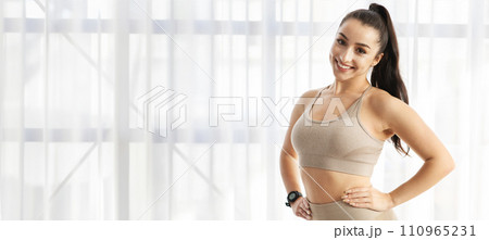 Attractive young sporty lady posing next to window 110965231