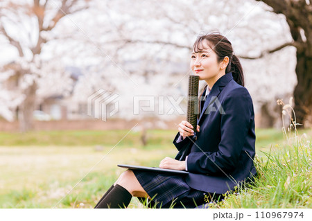 満開の桜の下に座る卒業証書を持つ高校生・女子高生(卒業生・卒業式・卒業) 満開の桜の下に座る卒業証書を持つ高校生・女子高生(卒業生・卒業式・卒業) 110967974