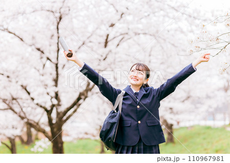 満開の桜の下でバンザイをする高校生・女子高生（卒業生・卒業式・卒業） 110967981