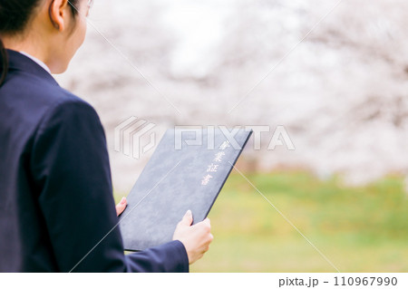 卒業証書を見つめる高校生・女子高生(卒業・卒業生・卒業式・桜) 卒業証書を見つめる高校生・女子高生(卒業・卒業生・卒業式・桜) 110967990