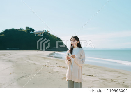 海辺でドローンを操作する女性(AI画像) 110968003