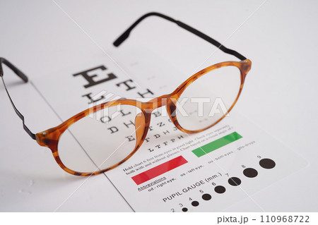 Glasses on eye exam chart to test eyesight accuracy of reading. Glasses on eye exam chart to test eyesight accuracy of reading. 110968722