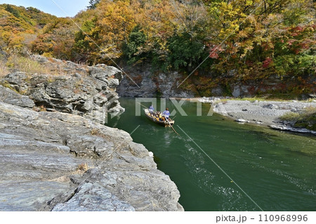 紅葉の長瀞渓谷の岩畳南端付近を流れる荒川に長瀞ライン下りの遊覧船 紅葉の長瀞渓谷の岩畳南端付近を流れる荒川に長瀞ライン下りの遊覧船 110968996