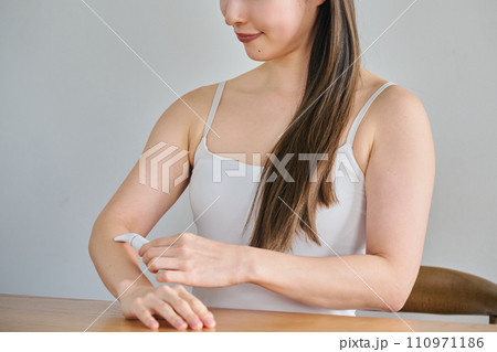 電気シェーバーで腕毛を剃る30代女性 電気シェーバーで腕毛を剃る30代女性 110971186