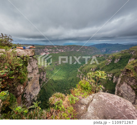 Daredevil Posing as Superman on a Cliff Edge with Forest View Daredevil Posing as Superman on a Cliff Edge with Forest View 110971267