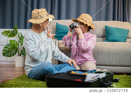 Travel and tourism. Asian couple old senior marry retired couple smiling taking photo by camera during luggage suitcase arranging for travel, Happy mature retired couple photography weekend holiday Travel and tourism. Asian couple old senior marry retired couple smiling taking photo by camera during luggage suitcase arranging for travel, Happy mature retired couple photography weekend holiday 110972719