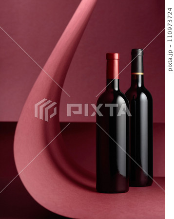Bottles of red wine on a red background. 110973724