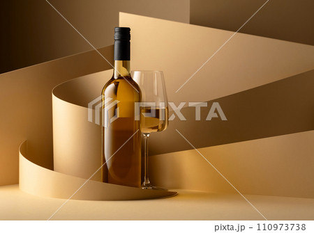 Bottle and glass of white wine on a beige background. 110973738