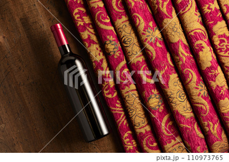 Bottle of red wine and retro tapestry with floral ornament. 110973765