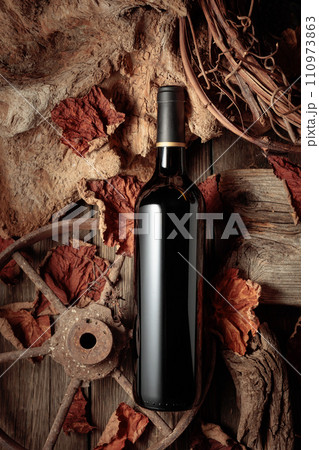 Bottle of red wine on a vintage rustic background. 110973863