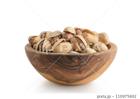 salted pistachios in wood bowl isolated on white background 110975602