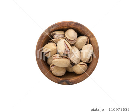 Top view of salted pistachios in wood bowl isolated on white background Top view of salted pistachios in wood bowl isolated on white background 110975655