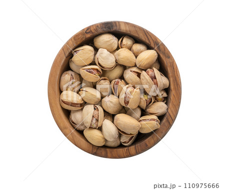 Top view of salted pistachios in wood bowl isolated on white background 110975666