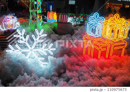 New Year and Christmas decorations, garlands, small architectural forms. Multi-colored light bulbs create festive atmosphere. A snowflake New Year and Christmas decorations, garlands, small architectural forms. Multi-colored light bulbs create festive atmosphere. A snowflake 110975673