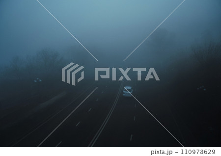 cars on a foggy road in city in morning in winter in fog mist cars on a foggy road in city in morning in winter in fog mist 110978629