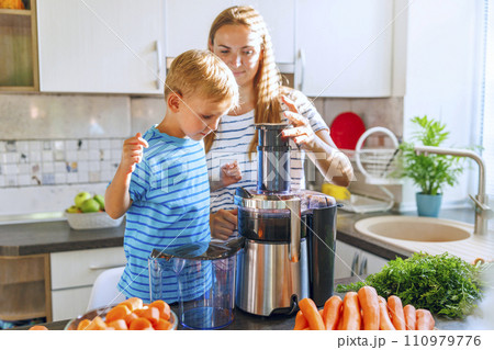 Mother and Son Making Fresh Juice in the Kitchen Mother and Son Making Fresh Juice in the Kitchen 110979776