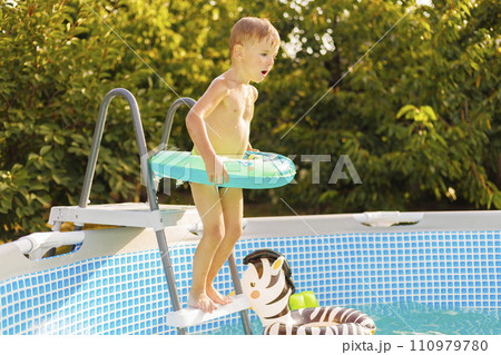 Young Boy Preparing to Jump into Swimming Pool Young Boy Preparing to Jump into Swimming Pool 110979780