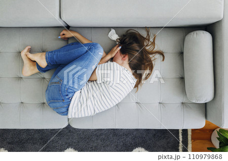 Distressed Woman Crying on Sofa 110979868