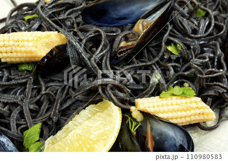 Black pasta with mussels and corn. 110980583