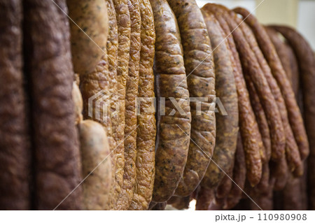 Fresh prepared smoked sausage with spices on market stall Fresh prepared smoked sausage with spices on market stall 110980908