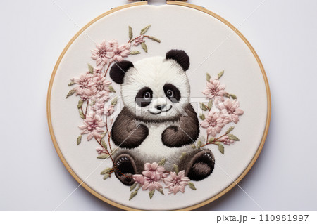 Embroidery of little panda among pink flowers in round frame 110981997