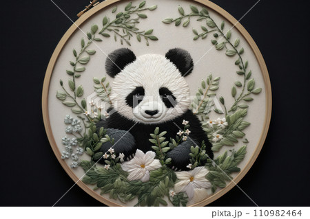 Embroidery of little panda among plants and flowers in round frame 110982464
