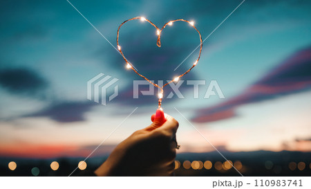 Holding A Heart Of Fairy Lights 110983741