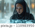 young woman in hijab working with futuristic transparent interface 110983950