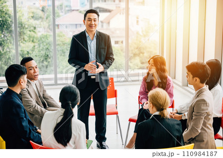 In a modern office, a diverse group of businesspeople plans, discusses, and presents in a business meeting seminar room. Their teamwork, diversity, and confidence drive success. 110984187