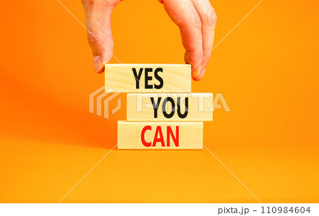 Motivational and Yes you can symbol. Concept words Yes you can on beautiful wooden blocks. Beautiful orange background. Businessman hand. Business motivational and Yes you can concept. Copy space. Motivational and Yes you can symbol. Concept words Yes you can on beautiful wooden blocks. Beautiful orange background. Businessman hand. Business motivational and Yes you can concept. Copy space. 110984604