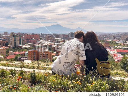 Love couple sitting high with panoramic view on Yerevan city and Ararat from Armenian cascade Love couple sitting high with panoramic view on Yerevan city and Ararat from Armenian cascade 110986103