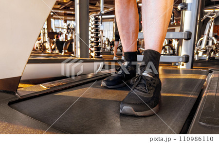 Legs, feet on cardio treadmill machine in gym. Cardio exercise Legs, feet on cardio treadmill machine in gym. Cardio exercise 110986110