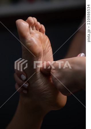 Close-up of a woman's foot massage. Vertical photo. 110986534