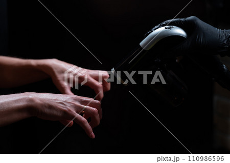 The master applies tinting paint to the woman's hands. Instant tanning procedure The master applies tinting paint to the woman's hands. Instant tanning procedure 110986596