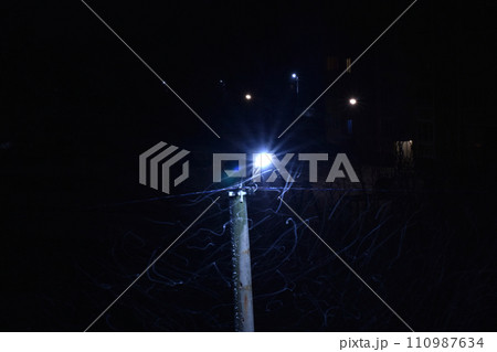A street lamp shines at night. 110987634