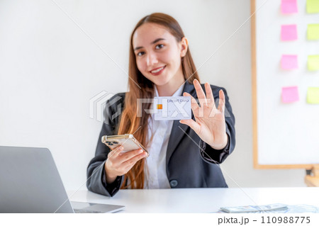 Caucasian businesswoman hand hold mock-up credit card for online shopping on smartphone or laptop computers from home office, payment e-commerce, internet finance bank, spend money electronic wallet Caucasian businesswoman hand hold mock-up credit card for online shopping on smartphone or laptop computers from home office, payment e-commerce, internet finance bank, spend money electronic wallet 110988775
