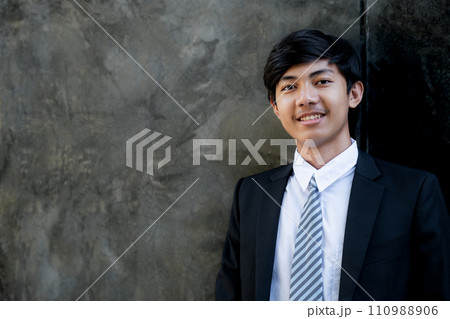 Young businessman financier investors stand with a luxurious black hotel building in the background 110988906