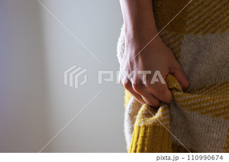 服を握った女性の手元、ダークなイメージ 服を握った女性の手元、ダークなイメージ 110990674