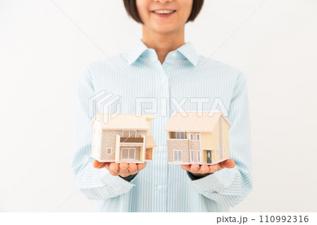 住宅模型を持って微笑むミドル女性 110992316