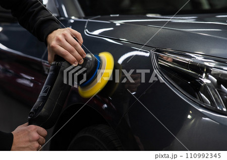 A master polishes the surface of a car body. A master polishes the surface of a car body. 110992345